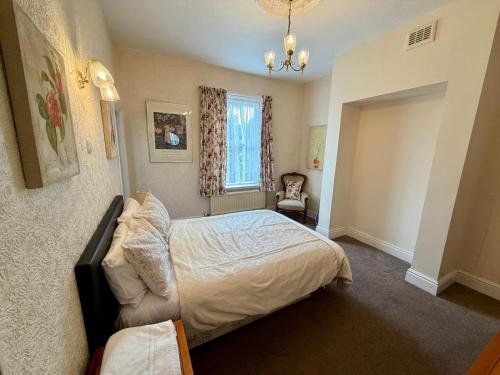 a bedroom with a bed and a chair and a window at 307 queens road Big double room with attached toilet and shower in Nottingham