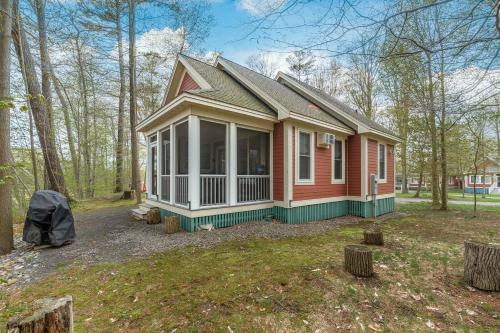 a small red house in the middle of a yard at The Tree Frog - 12 Pine Forest in Cherry Valley