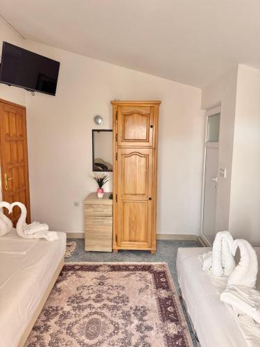 a bedroom with two beds and a wooden door at Apartments Zeneva in Donji Štoj