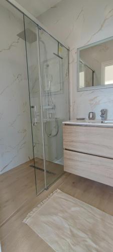 une salle de bain avec une douche, un lavabo et un miroir dans l'établissement Exceptional sea view apartment, Monaco 15 min, à La Turbie