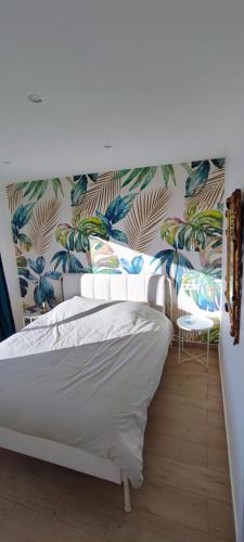 - une chambre avec un lit blanc et un papier peint tropical dans l'établissement Exceptional sea view apartment, Monaco 15 min, à La Turbie
