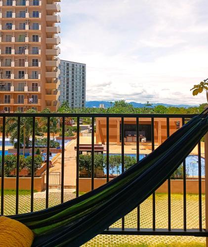 a hammock on the balcony of a resort at Homey Apartment with Olympic-sized pools in Lapu Lapu City