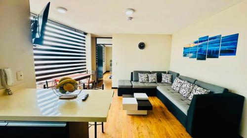 una sala de estar con un sofá y una mesa en The OLIMPO Suite, en Cuenca