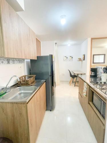 a kitchen with a sink and a black refrigerator at Comfortable and central apartment in Bquilla in Barranquilla