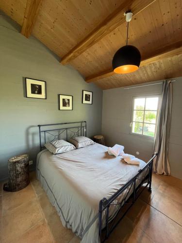 une chambre avec un grand lit avec un plafond en bois dans l'établissement Maison L union, à Beauvoir-sur-Mer