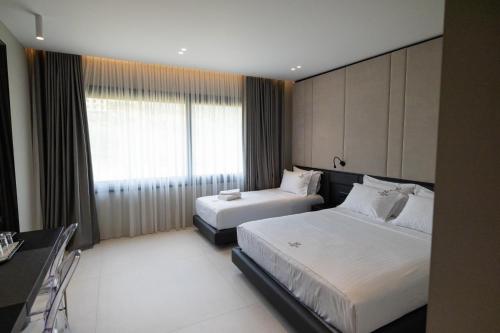 a hotel room with two beds and a window at Hotel Majestic in Vlorë