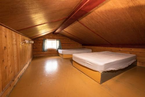a room with two beds and a window in it at Chalet de la Berge 2 in Murdochville