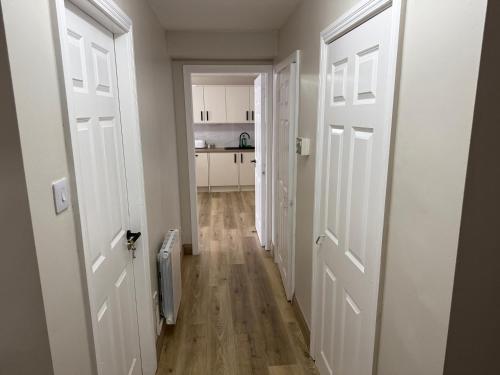a hallway with two white doors and a kitchen at Seaview Flat Cobh in Cobh