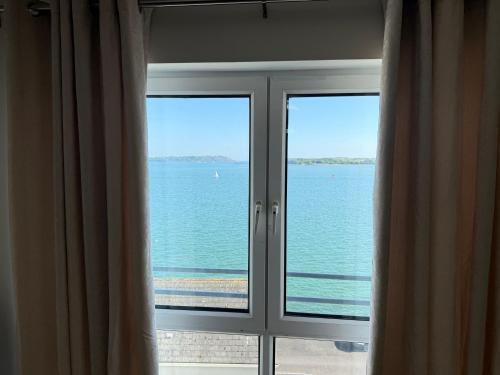 a window with a view of the ocean from a hotel room at Seaview Flat Cobh in Cobh