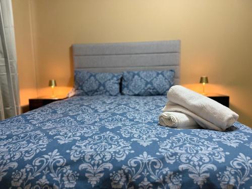 a blue bed with two towels on top of it at Seaview Flat Cobh in Cobh