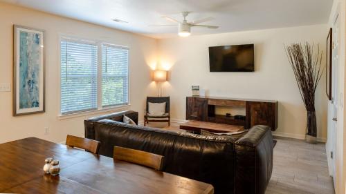 a living room with a leather couch and a table at Watermen's Cabana 1B - 2-Bed, 1-Bath Apartment - Walk To BEACH Access & PET Friendly! in Waves