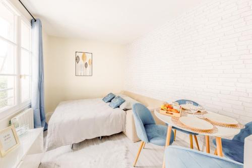 une chambre avec un lit, une table et des chaises dans l'établissement Versailles chic et cosy, à Versailles