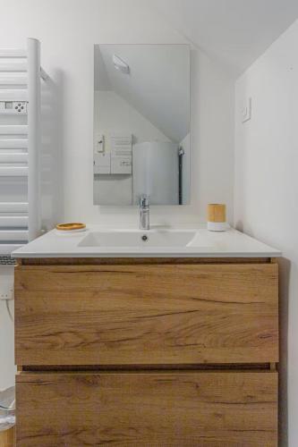 une salle de bain avec un lavabo et un miroir dans l'établissement Refuge Marin, à Sarzeau