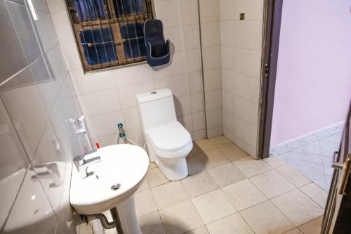 Un baño con inodoro, lavabo y ducha. en Bienvenido a casa villa, en Arusha