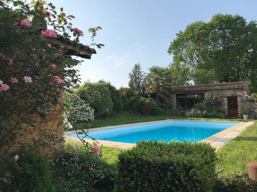 une piscine dans la cour d'une maison dans l'établissement Gîte de charme avec piscine dans un environnement bucolique, à Les Forges