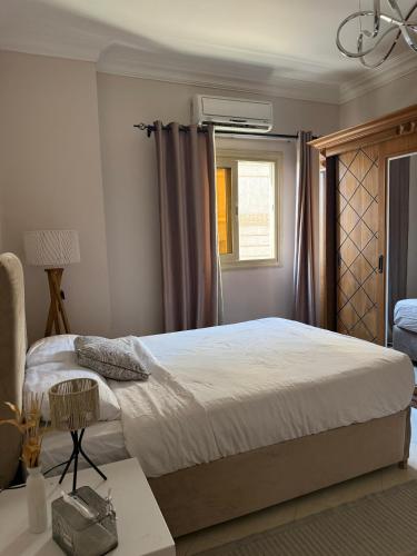 a bedroom with a large bed and a window at فيلا مبهجة مع مسبح وحديقة رائعة in 6th Of October
