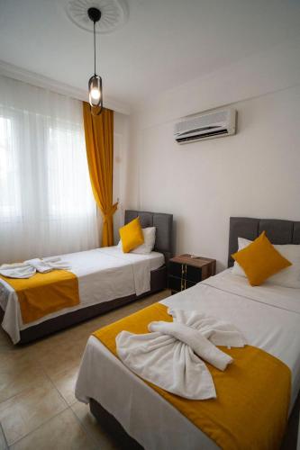 a hotel room with two beds with towels on them at HONEY SUİTEs 1 in Fethiye