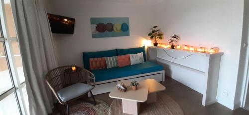 un salon avec un canapé bleu et une table dans l'établissement Résidence le Village de Cap Esterel - maeva Home - Appartement 2 pièces 5 personnes - Prestige MAE-6341, à Saint-Raphaël