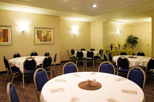 a room with round tables and chairs and a room with tables and chairsktop at Holiday Inn Express & Suites-Regina-South by IHG in Regina