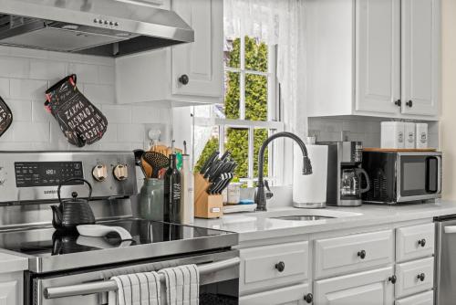 a kitchen with a sink and a stove top oven at Charming Historic Schoolhouse on Mystic River in Groton