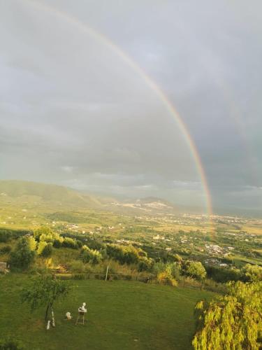 a rainbow over a green field with a group of people at Villa Dei Romani - Country House in Guidonia