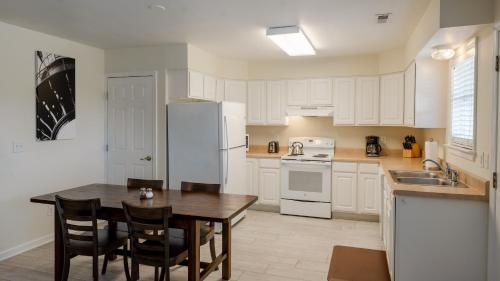 a kitchen with white cabinets and a table with chairs at Watermen's Cabana 2B - 2-Bed, 1-Bath - Walk To BEACH Access & PET Friendly! in Waves