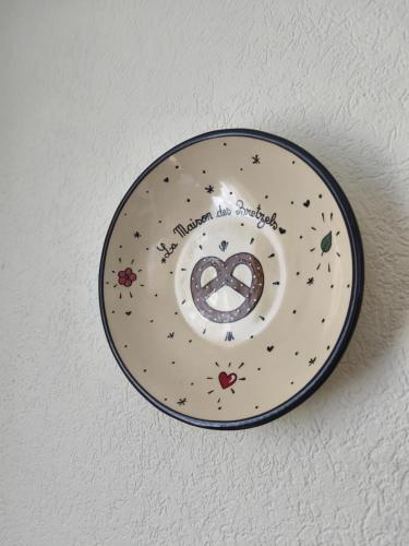 a plate with a peace sign on a wall at La maison des Bretzels GÎTE jacuzzi et charme Alsacien in Pfaffenhoffen