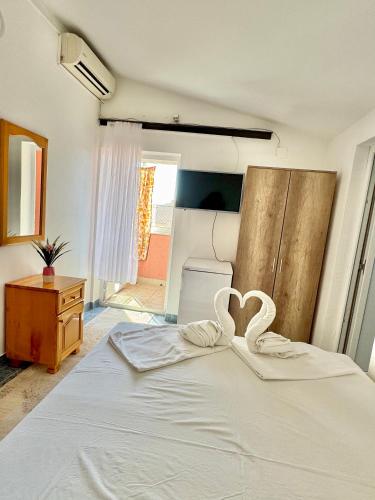 a bedroom with a bed with two hearts on it at Apartments Zeneva in Donji Štoj