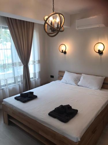 a bedroom with a bed with two black towels on it at Апартаменти ''Димови'' in Lozenets