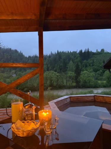 a table with candles and a view of a bath tub at Чан-садиба Гуцульська пісня in Mykulychyn