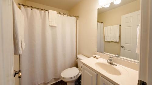 a bathroom with a sink and a toilet and a mirror at Watermen's Cabana 3A - 3-Bed, 2-Bath Apartment - Walk To BEACH Access & PET Friendly! in Waves
