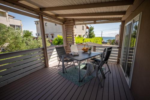 a patio with a table and chairs on a deck at House 4 Mali Nordsee Camp in Pakoštane