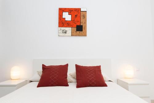 a bedroom with a white bed with red pillows at Los Miradores Two Bedroom Apartment La Manga Club RPM387 in Atamaría