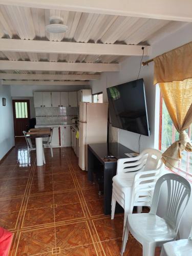a living room with a table and chairs and a television at FINCA LA BENDICION in Santa Rosa de Cabal