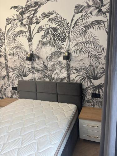 ein Schlafzimmer mit einem Bett vor einer Wand in der Unterkunft Drzewna Apartamenty-Wojska Polskiego in Zielona Góra