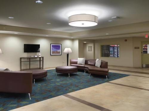 a lobby with couches and chairs and a television at Candlewood Suites - Newark South - University Area by IHG in Newark
