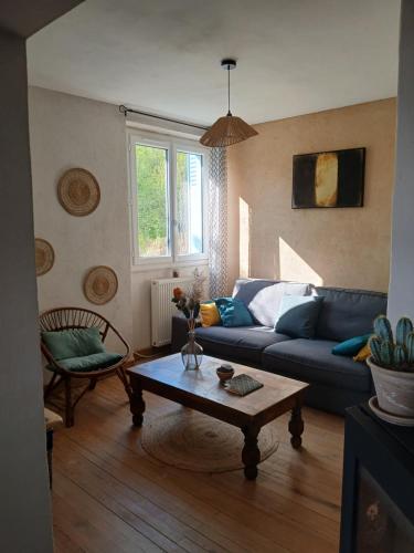 a living room with a blue couch and a coffee table at Les Gîtes du Saro in Chabestan