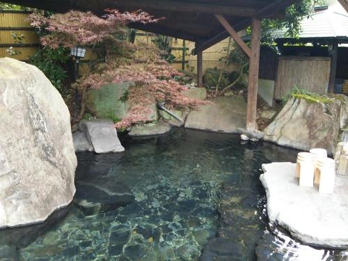a koi pond in a japanese garden at Pension Yufuin in Yufuin
