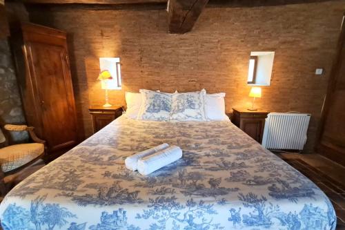 a bedroom with a bed with a blue and white bedspread at La Bastide des Chézeaux - Brenne in Rivarennes