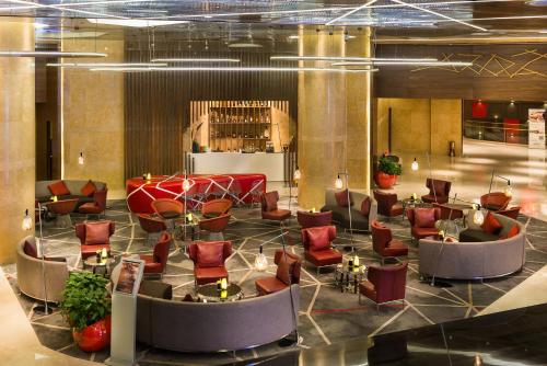 a lobby with red chairs and a waiting room at Pullman Nanjing Lukou Airport in Nanjing