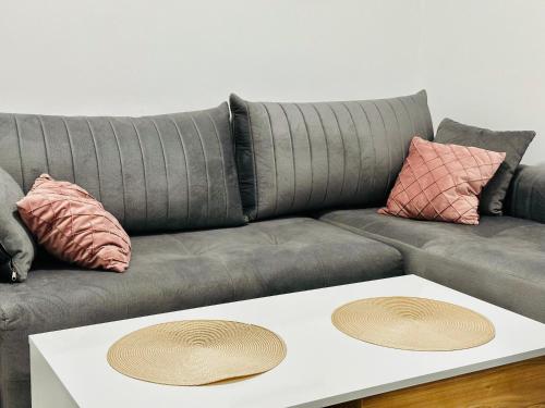 a gray couch with two pillows and a coffee table at MorePlanina in Sutomore