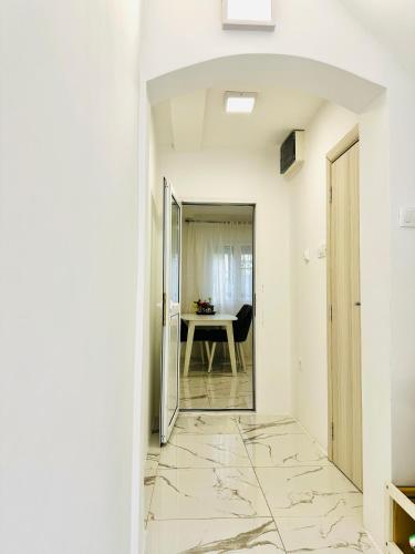 a hallway with white walls and marble floors and a table at MorePlanina in Sutomore