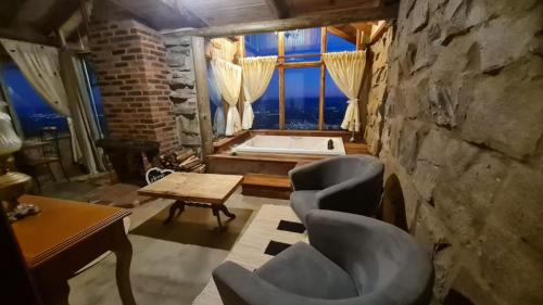 a room with a bath tub and chairs and a table at Porta Garibaldi - Pousada e Cabanas in Igrejinha