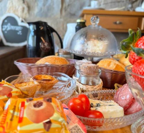 Una mesa cubierta con cestas de comida y tomates. en Porta Garibaldi - Pousada e Cabanas, en Igrejinha