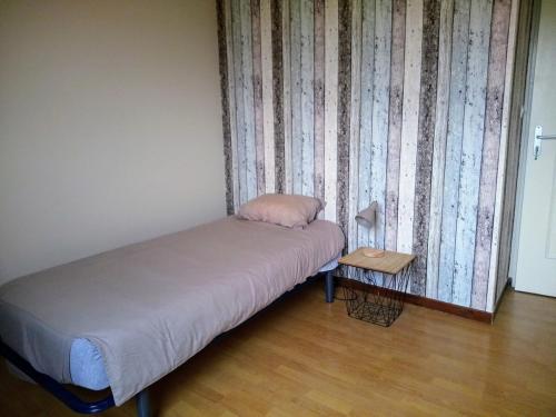 a bedroom with a bed and a side table at L idéal in Lagnieu
