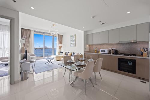 a kitchen and living room with a table and chairs at YOUR STAY APARTMENTS Luxury Beachfront Living in Dubai