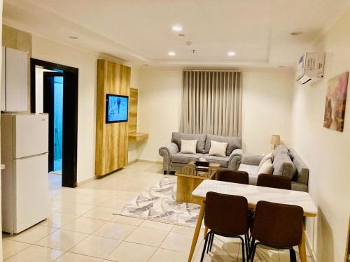 a living room with a couch and a table and chairs at تولين بارك in Taif