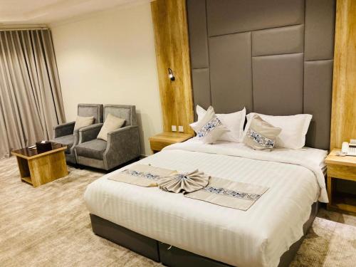a hotel room with a bed and a chair at تولين بارك in Taif