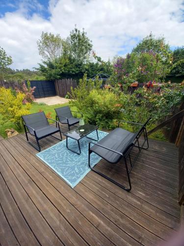 two chairs and a table on a wooden deck at La cabane au fond du jardin in Le Massegros