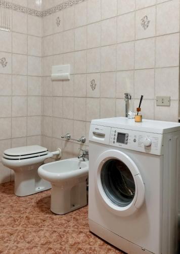 a bathroom with a washing machine and a toilet at Casa Vacanze Mari, Paratico in Paratico